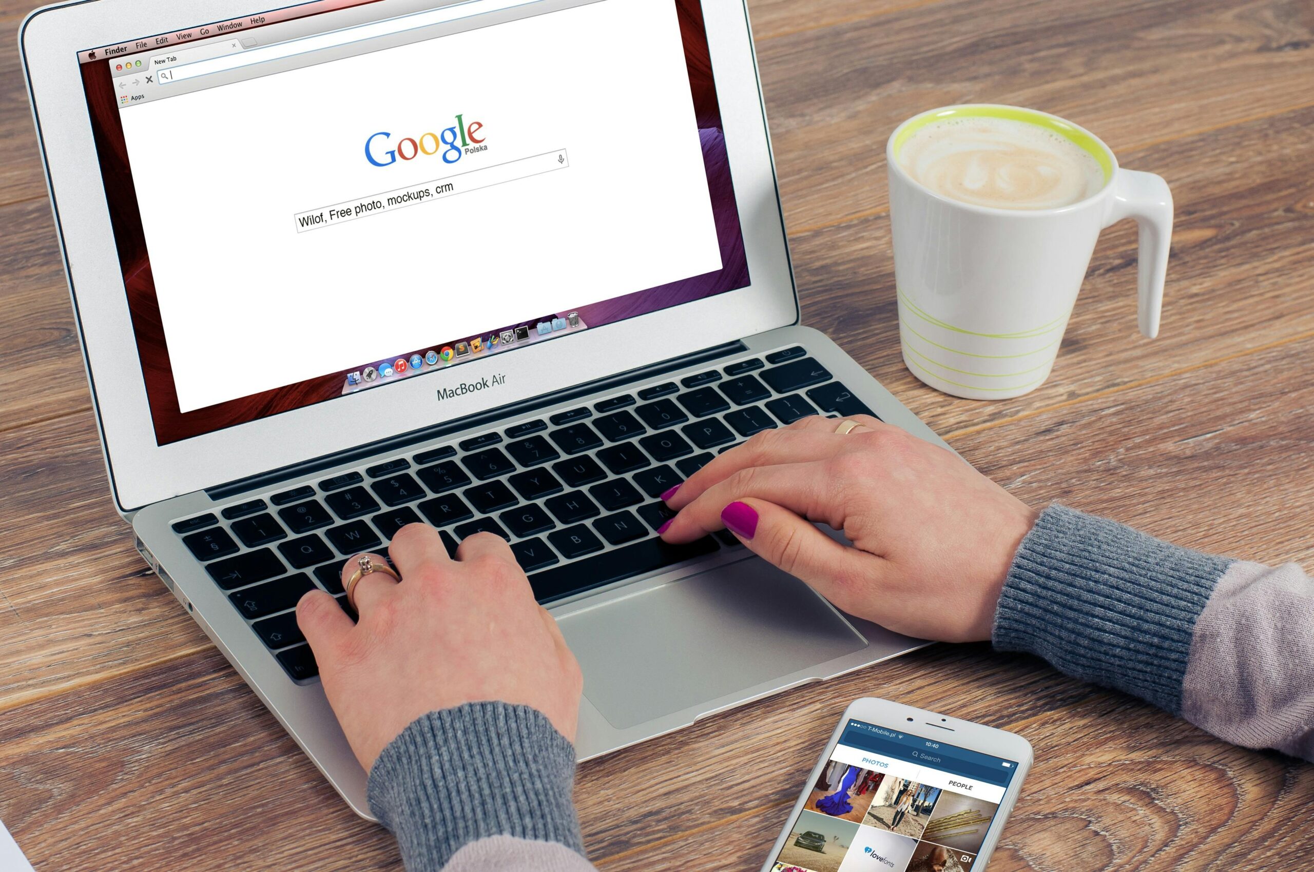 image of a woman's hands typing on a laptop computer.